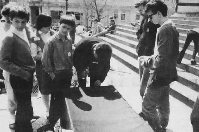 A student knocks a nail into the coffin during the rally in Guildhall Square
