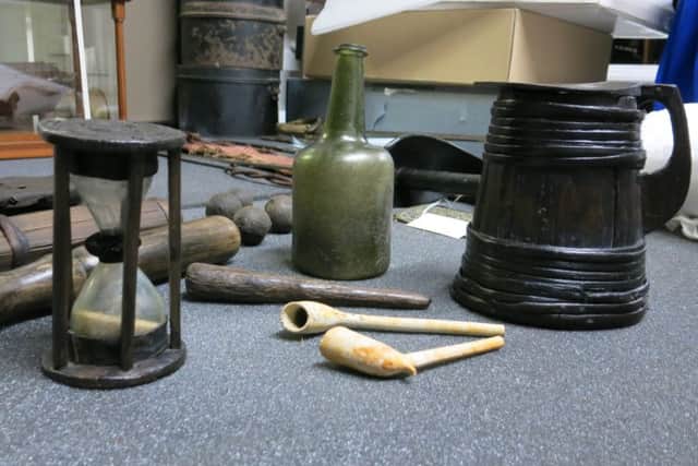 Donated artefacts from HMS Invincible include (from left)  sand glass, clay pipes, wine bottle andd  tankard with the initials of sailor Issac Robertson engraved on it