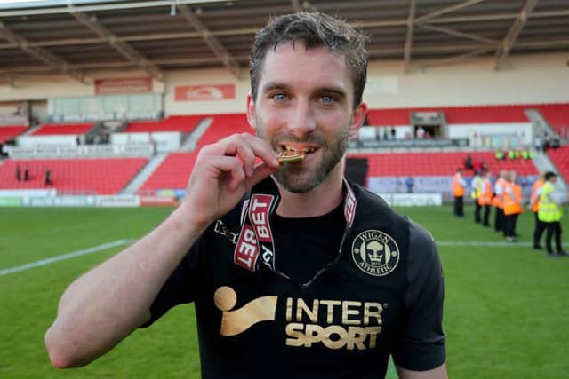 Will Grigg celebrates winning the title at Doncaster