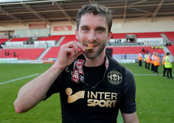 Will Grigg celebrates winning the title at Doncaster
