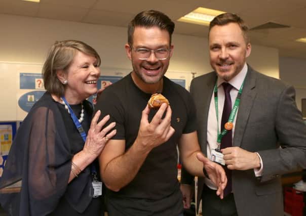KING TUTT Masterchef winner Kenny Tutt tucks into the winning cake watched by Melloney Poole, the chairman of Portsmouth Hospitals NHS Trust and chief executive Mark Cubbon Picture: Habibur Rahman