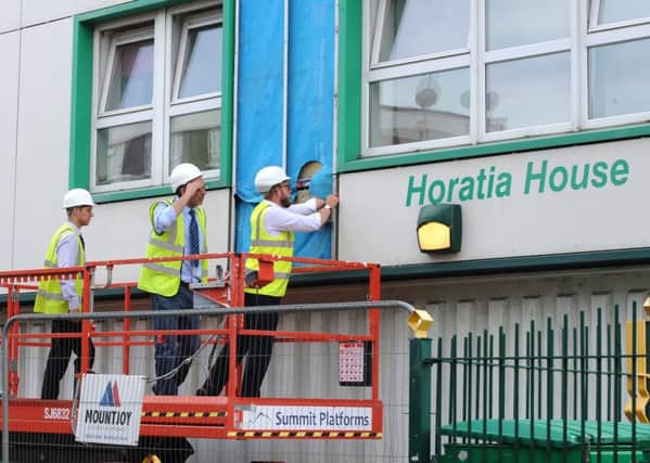 Workers removing cladding from Horatia House last year Picture: Sarah Standing (170831-9641)