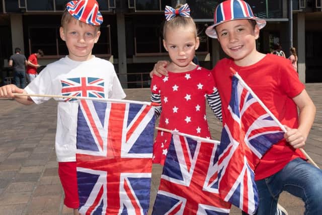 Alex and Lilly Eldridge, four, with Ryan Goddard, 10, from Waterlooville at Guildhall Square in Portsmouth to watch the royal wedding. Picture: Keith Woodland 180291