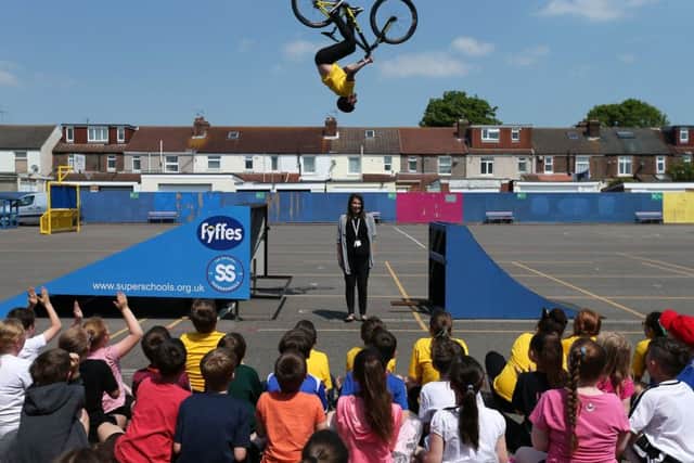 Grant Fielder in action, airborne above headteacher Mrs Bush during his visit to Langstone Junior School Portsmouth with Olympic swimmer Katy Sexton 
     Picture: Chris Moorhouse