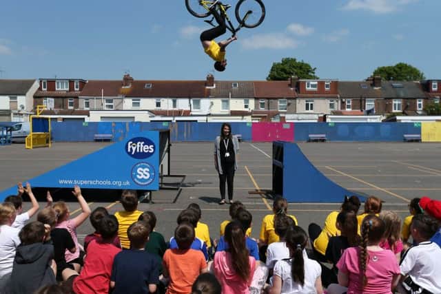 Grant Fielder in action, airborne above headteacher Mrs Bush during his visit to Langstone Junior School Portsmouth with Olympic swimmer Katy Sexton 
     Picture: Chris Moorhouse