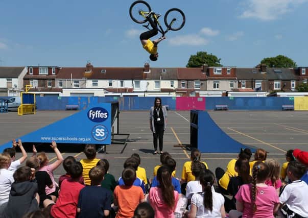 Grant Fielder in action, airborne above headteacher Mrs Bush during his visit to Langstone Junior School Portsmouth with Olympic swimmer Katy Sexton 
     Picture: Chris Moorhouse