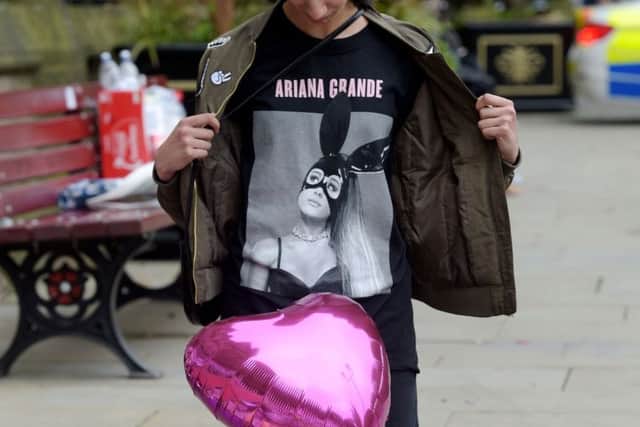 Iqra Saied, 13, wears an Ariana Grande t-shirt as she looks at flowers outside Manchester Town Hall in Manchester on Wednesday May 24, 2017. Ben Birchall/PA Wire PPP-170524-150646001