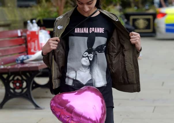 Iqra Saied, 13, wears an Ariana Grande t-shirt as she looks at flowers outside Manchester Town Hall in Manchester on Wednesday May 24, 2017.  Ben Birchall/PA Wire PPP-170524-150646001
