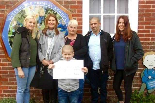 From left, Gemma Frost, Monica Bowen, Reggie's mum and dad, Catherine Burton and Reggie, front, holding the cheque