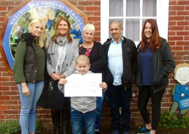 From left, Gemma Frost, Monica Bowen, Reggie's mum and dad, Catherine Burton and Reggie, front, holding the cheque
