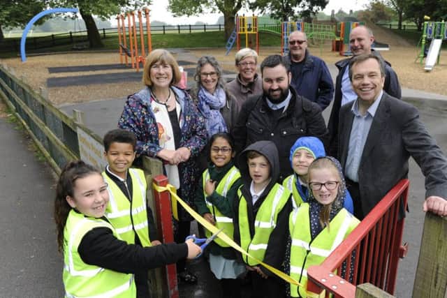 A new look play park has been opened at Baffins pond by children from Langstone Infants School. Councillor Lynne Stagg helps Lilia Paine (seven), cut the ribbon.Picture Ian Hargreaves  (180488-1)