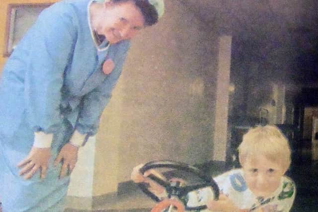 Lee Stace, four, is greeted by theatre receptionist Jessica Willis as he tries out the new transport. PPP-180626-221723001