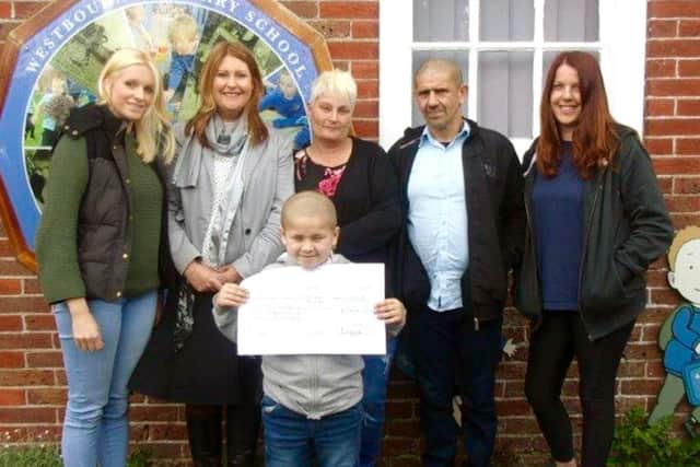 From left, Gemma Frost, Monica Bowen, Reggie's mum and dad,  Catherine Burton and Reggie, front, holding the cheque