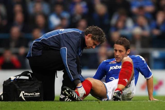 Physio Steve Allen gives treatment to former Pompey captain Michael Brown