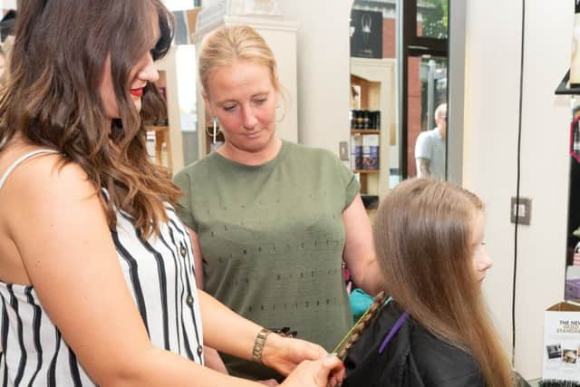 Jodie Slingsby and Cheryl Bremmer measure how much hair they are going to cut off Isla.
Picture: Keith Woodland