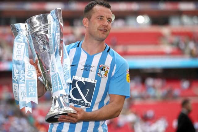Coventry City's Michael Doyle lifts the trophy after his side win promotion to League One