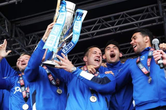 Michael Doyle holds aloft the League Two trophy