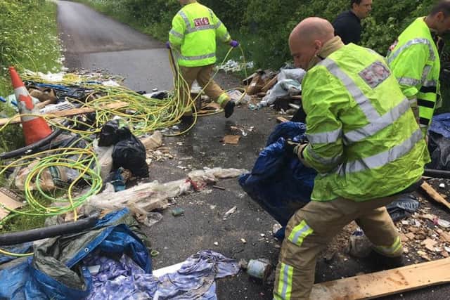 Firefighters struggled to remove the rubbish scattered on the road as they were travelling to an emergency call   PHOTO: West Sussex Fire and Rescue Service e6yTfi-aTyPAvA_5x_Cl