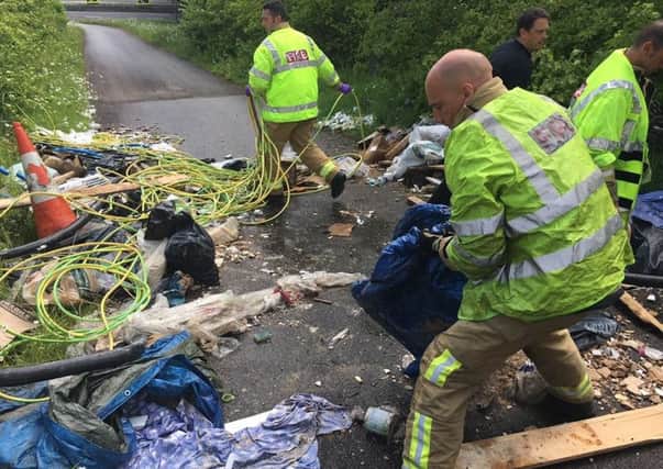 Firefighters struggled to remove the rubbish scattered on the road as they were travelling to an emergency call   PHOTO: West Sussex Fire and Rescue Service e6yTfi-aTyPAvA_5x_Cl
