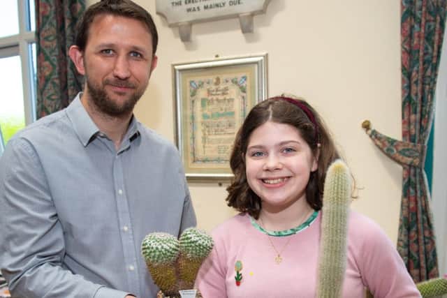 Judge Gareth Darbon with Bailey Hamilton who is the youngest member of the branch holding her winning specimens Mammillaria and Espostoa
 (180386-209)