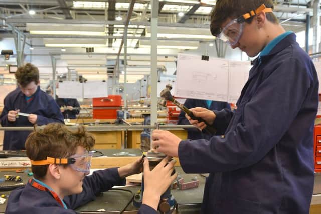 Ben Medze-Kitching, left, assists Nathan Daw with his project at HMS Sultan
