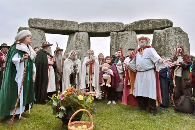Mid-summer, but autumn beckons. Revellers, druids and pagans at Stonehenge