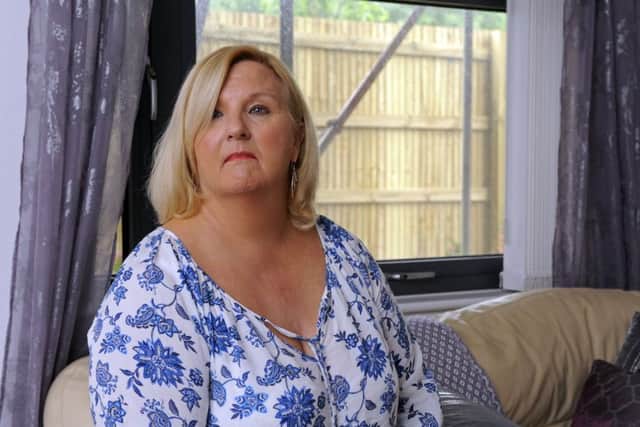 Tracey Hollingdale  at her flat in Ark Royal House, Blanchard Avenue, Gosport, with the fence and scaffolding visible through the window