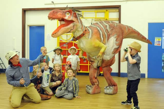 Purbrook Infant School Assistant Headteacher Paul Stray holds on tight to Dino Pete's head collar
Picture by Malcolm Wells (180614-3956)