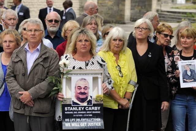 Families holding pictures of loved ones who died at Gosport War Memorial Hospital