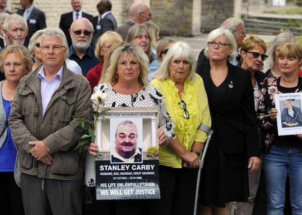 Families holding pictures of loved ones who died at Gosport War Memorial Hospital