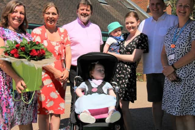 Naomi House continued its annual tradition of paying its rent with red roses. Pictured are: Dr Rosemary Reid, two-year-old Emily Smith, David and Naomi Cornelius-Reid, Amy and Adam Smith, and Naomi House & Jacksplace Director of Care and Deputy Chief Executive, Lesley Brook.
 Picture: Naomi House