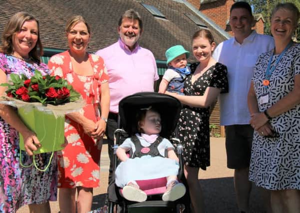 Naomi House continued its annual tradition of paying its rent with red roses. Pictured are: Dr Rosemary Reid, two-year-old Emily Smith, David and Naomi Cornelius-Reid, Amy and Adam Smith, and Naomi House & Jacksplace Director of Care and Deputy Chief Executive, Lesley Brook.
 Picture: Naomi House