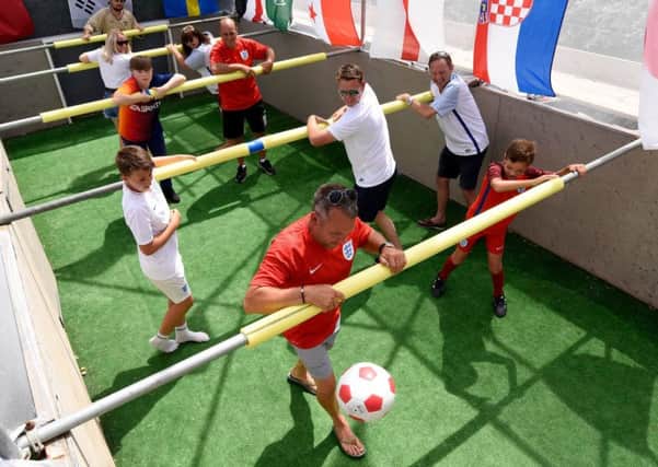 People playing on the life sized table football pitch built by Iain-Paul Hutton in his garden for the World Cup Picture: Tom Harrison/Solent News & Photo Agency