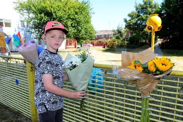 Jack Rogers, 10, laying flowers at the play park in memory of Leo