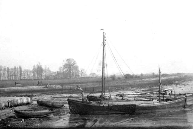 Kate on the northern side of Port Creek, Cosham, about 1920, next to a wharf made of wooden piles.