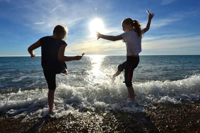 Children splashing in the sea with ice creams during unseasonably warm weather.© Peter Cripps SUS-180628-084808008