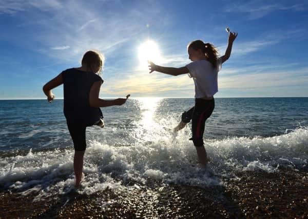 Children splashing in the sea with ice creams during unseasonably warm weather.© Peter Cripps SUS-180628-084808008