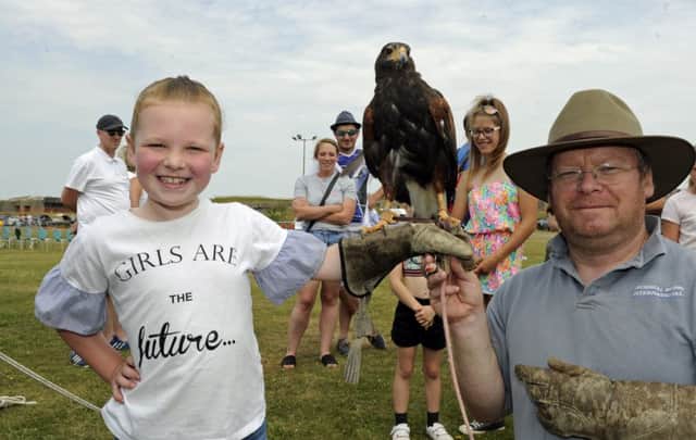 A family funday has been held at Fort Purbrook. (l to r), Millie Upfield from Waterlooville (seven), meets a bird of prey with handler Dennis Rogers from Denmead. Picture Ian Hargreaves (180701-2_fun)