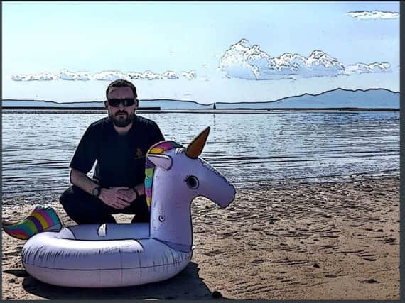A member of the rescue teams with a recovered inflatable unicorn