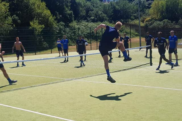 Jack Whatmough heads over the net during the football tennis tournament.