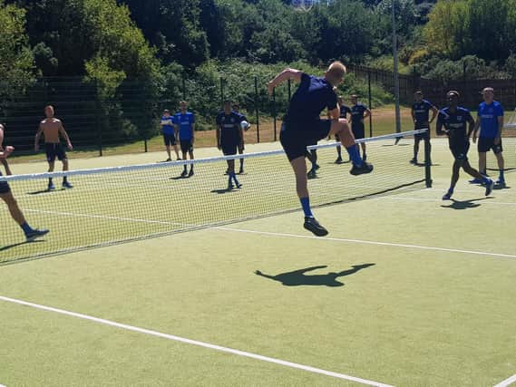 Jack Whatmough heads over the net during the football tennis tournament.