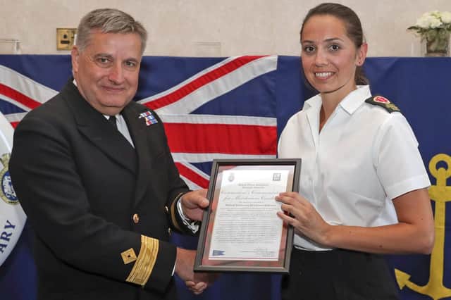 Pictured is Medical Technician Emma Robinson receiving the Commodores Commendation for Meritorious Conduct from Commodore Duncan Lamb