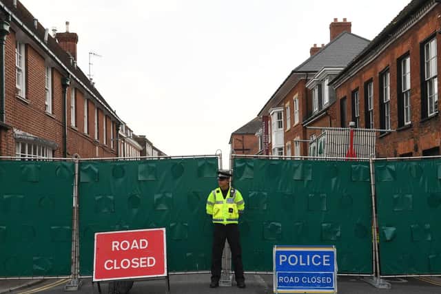 A police officer stands in front of screens erected in Rollestone Street, Salisbury, Wiltshire, where counter-terrorism police are investigating after a couple were left in a critical condition. Picture: Stefan Rousseau / PA Wire