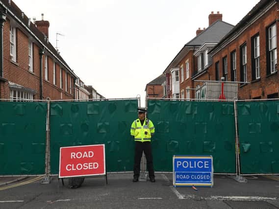 A police officer stands in front of screens erected in Rollestone Street, Salisbury, Wiltshire, where counter-terrorism police are investigating after a couple were left in a critical condition. Picture: Stefan Rousseau / PA Wire