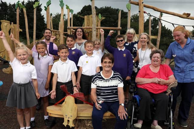Wellington Vale care home residents Sandra Smith (in blue and white) and Eve Campion (in pink) and Berewood Primary School's school council at the unveiling of a bench in Newlands Walk play area that the residents helped to design. Picture: Chris Moorhouse