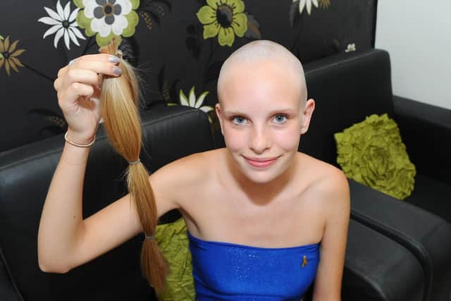 Georgia Brickell holding her ponytail after she had her head shaved for Cancer Research. Picture: Sarah Standing