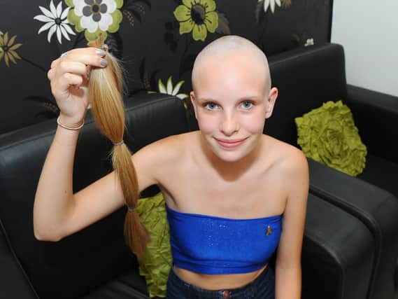 Georgia Brickell holding her ponytail after she had her head shaved for Cancer Research. Picture: Sarah Standing