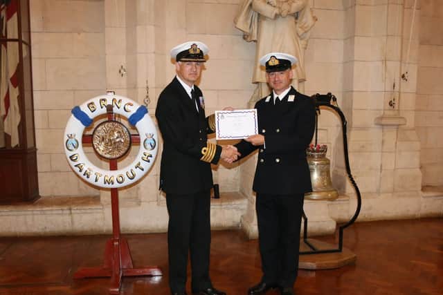 Mid Clive Bull, right, receiving his certificate from Captain Paul Hill, Captain RNR Operational Support