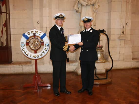 Mid Clive Bull, right, receiving his certificate from Captain Paul Hill, Captain RNR Operational Support