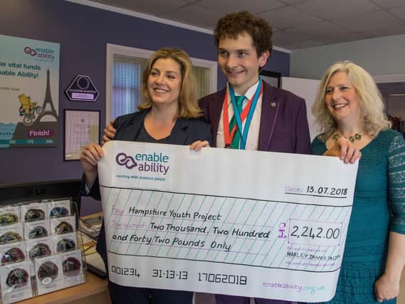 Harley Salter with Portsmouth North MP Penny Mordaunt, left, and his mother Vanessa, right - alongside his charity cheque